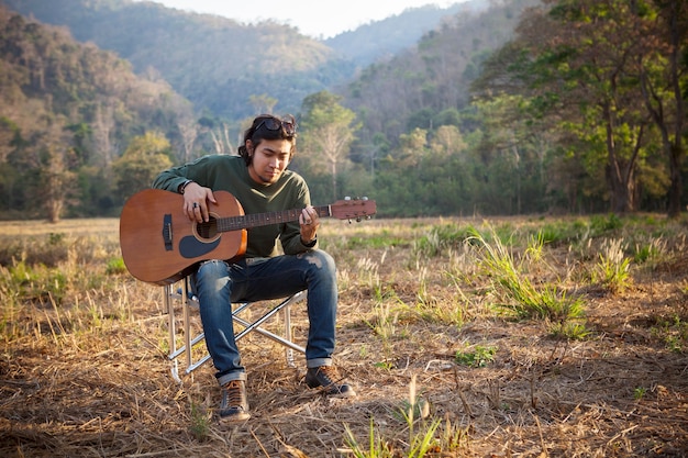 Homem asiático tocando violão no local