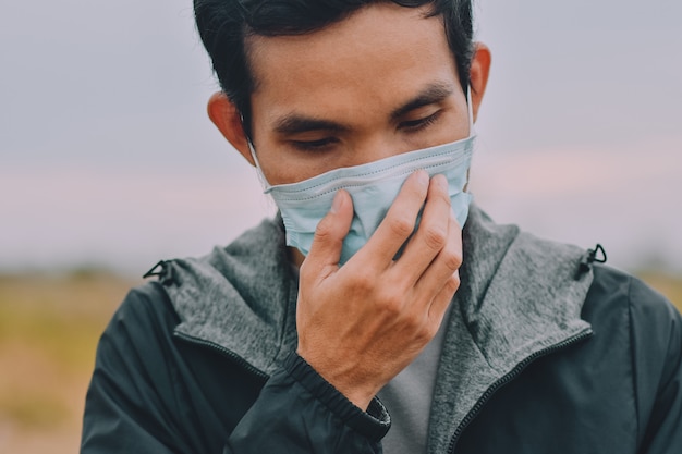 Homem asiático usa máscara cirúrgica ou máscara facial para proteger o vírus corona 2019 ou o covid 19 em público