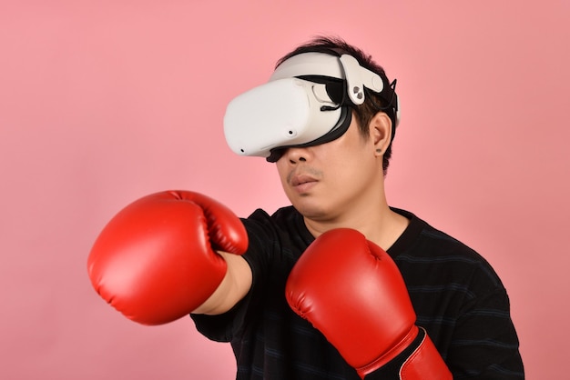 Homem asiático usando óculos vr malhando com aplicativo de videogame de boxe do fone de ouvido de realidade virtual Jovem desfruta de uma nova experiência de fitness pela tecnologia vr Studio shot