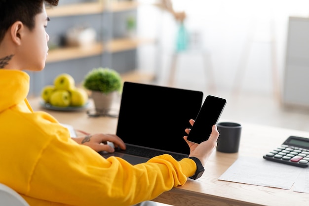 Homem asiático usando smartphone com tela preta vazia