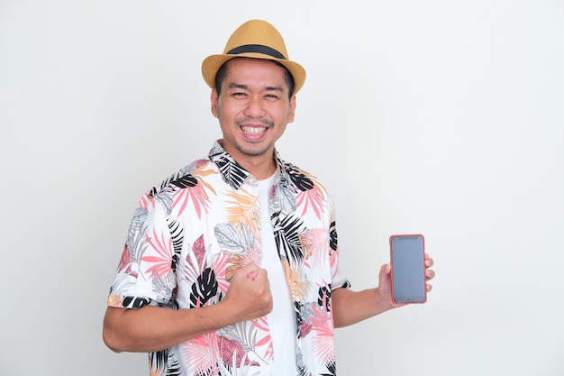 Homem asiático vestindo camisa de praia mostrando a tela do handphone em branco com animado