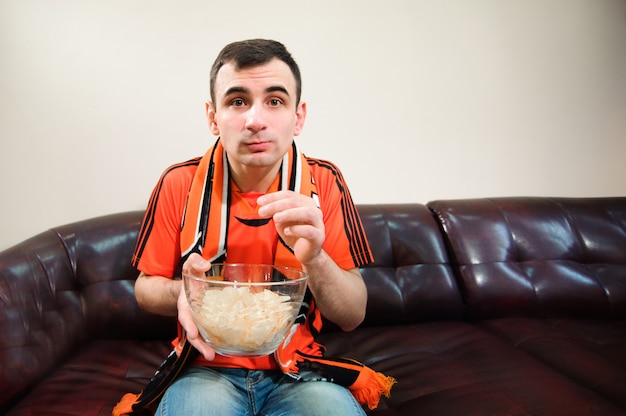 Homem assistindo futebol, fã de futebol, esportes em casa.