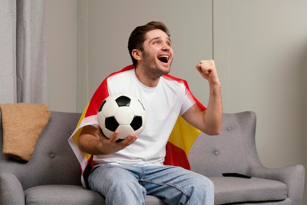 Homem assistindo programa de esporte na tv