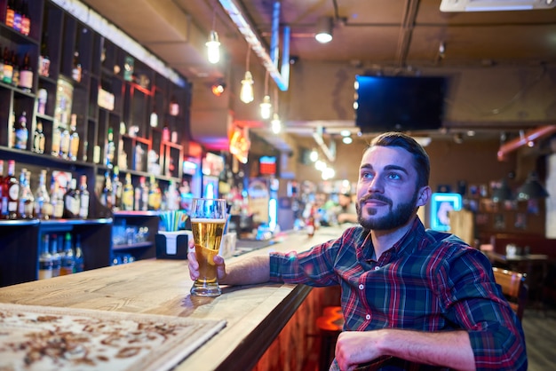 Homem assistindo tv no bar de cerveja