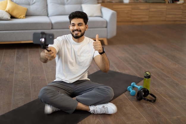 Homem ativo fazendo tutorial em vídeo via smartphone em casa