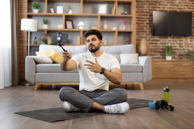 Homem ativo fazendo tutorial em vídeo via smartphone em casa