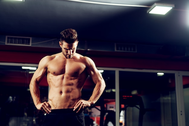 Homem ativo fitness está de pé no ginásio.