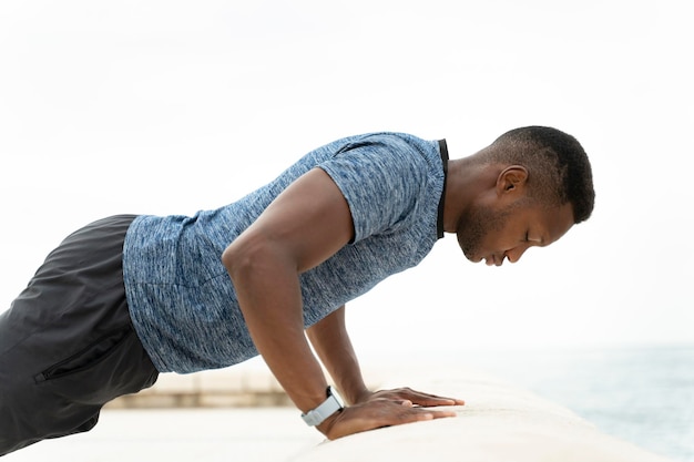 Homem ativo saudável com corpo musculoso em forma fazendo exercícios de flexões