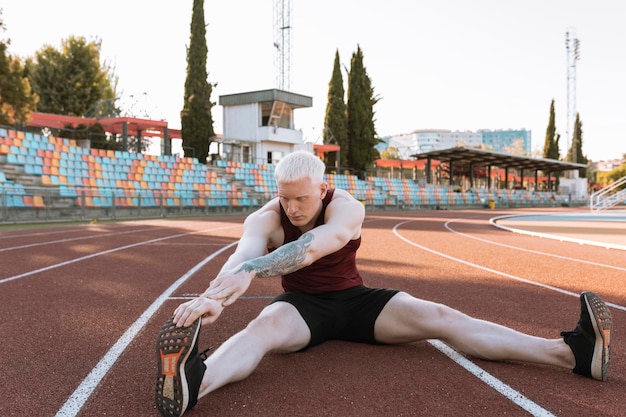 Homem atleta estica as pernas antes de correr