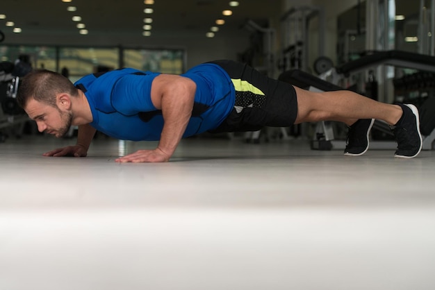 Homem atleta fazendo flexões no chão