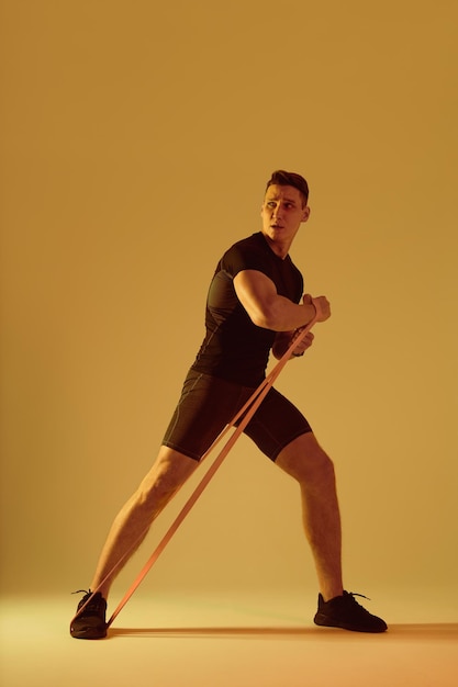 Homem atlético com treinamento de corpo musculoso em forma no estúdio