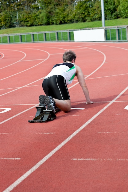 Foto homem atlético esperando no bloco de partida