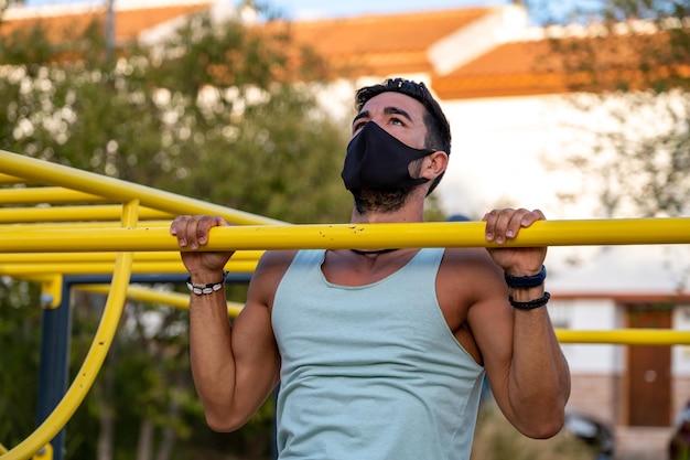 Homem atlético exercitando chin-ups no playground