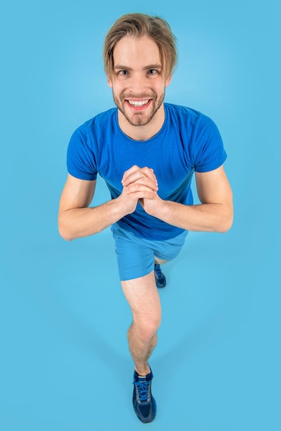 Homem atlético faz fitness isolado em fundo azul homem atlético pratica fitness em estúdio