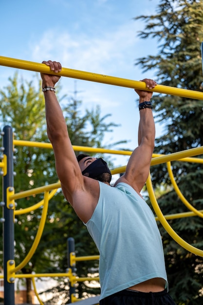 Homem atlético fazendo chin-ups no playground