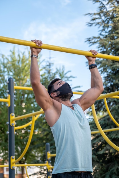 Homem atlético fazendo chin-ups no playground