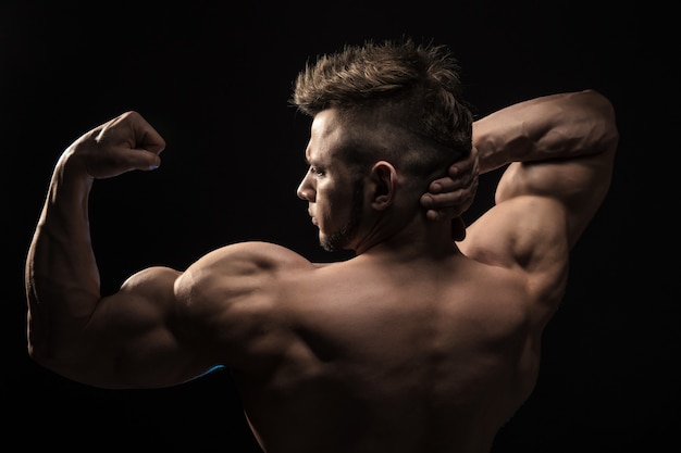 Foto homem atlético forte fitness modelo posando os músculos das costas.