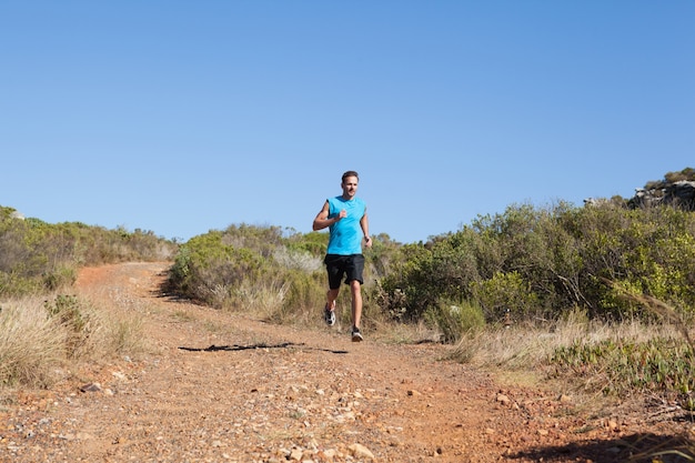 Foto homem atlético jogging na trilha rural