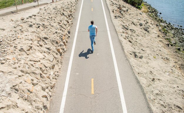 homem atlético maduro correndo na estrada ao ar livre, maratona.