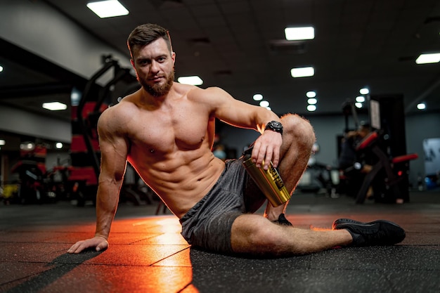 Homem atlético sem camisa com torso muscular Forte fisiculturista mostrando seus músculos