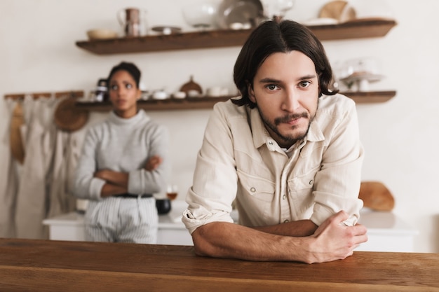 Foto homem atraente com barba encostado na mesa e pensativo