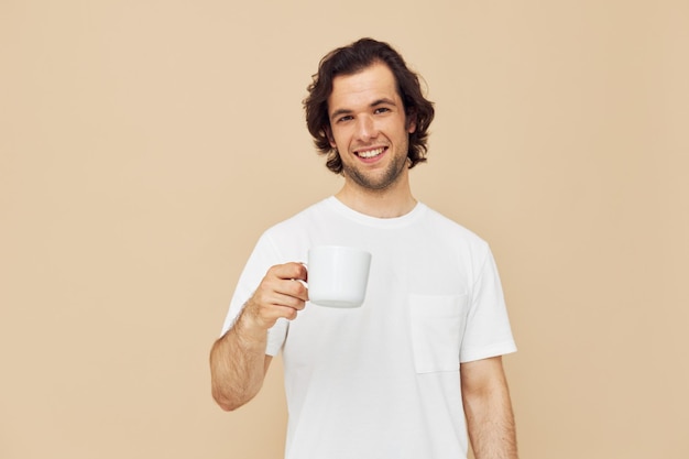 Homem atraente com uma caneca branca nas mãos emoções posando de fundo isolado