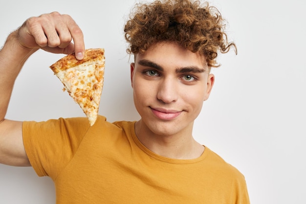 Homem atraente comendo pizza posando fundo isolado closeup