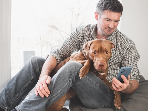 Homem atraente e adorável, lindo cachorrinho de cor marrom