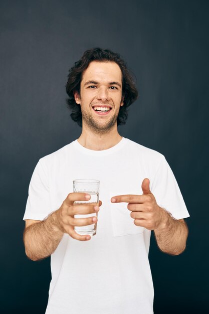 Homem atraente em uma camiseta branca copo de água Estilo de vida inalterado