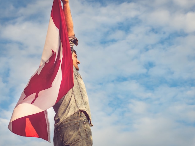 Homem atraente, segurando a bandeira do canadá