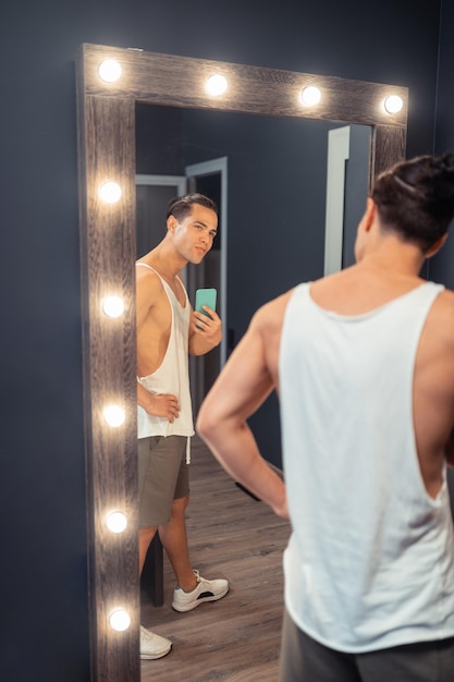 Homem atraente, segurando seu smartphone moderno