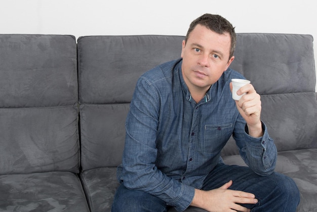 Homem atraente tomando um café em uma sala de estar