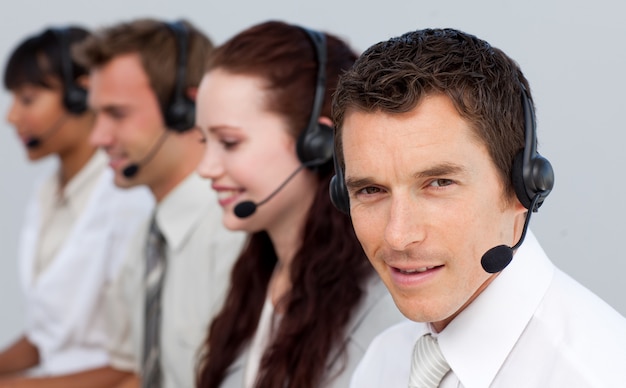 Homem atraente, trabalhando com sua equipe em um call center