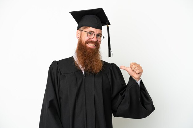 Homem avermelhado graduado da universidade jovem isolado no fundo branco orgulhoso e satisfeito