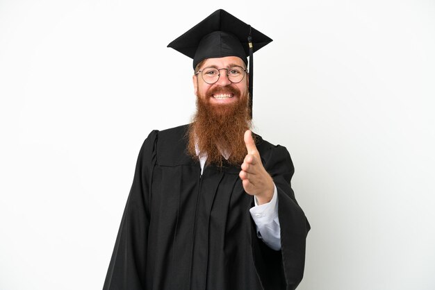 Homem avermelhado jovem graduado universitário isolado em fundo branco apertando as mãos para fechar um bom negócio