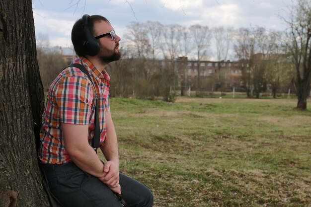 Homem barba ouvindo música no parque