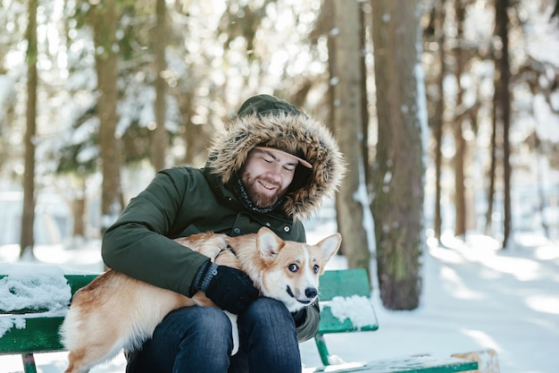 Homem barbudo abraça seu cachorro corgi