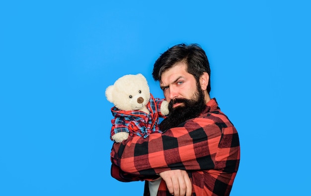 Homem barbudo abraçando o presente do ursinho de pelúcia e o conceito atual de homem barbudo com um brinquedo de pelúcia na moda e estilo