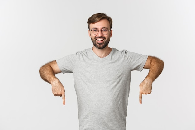 Homem barbudo alegre sorrindo, apontando o dedo para baixo