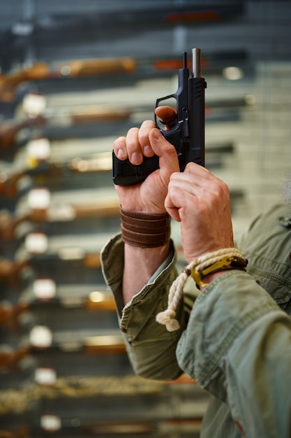 Foto homem barbudo aperta o parafuso da pistola na loja de armas