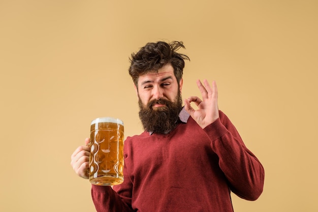 Homem barbudo bêbado hippie segurando cerveja artesanal, maus hábitos, homem barbudo bebendo cerveja em vidro no bar