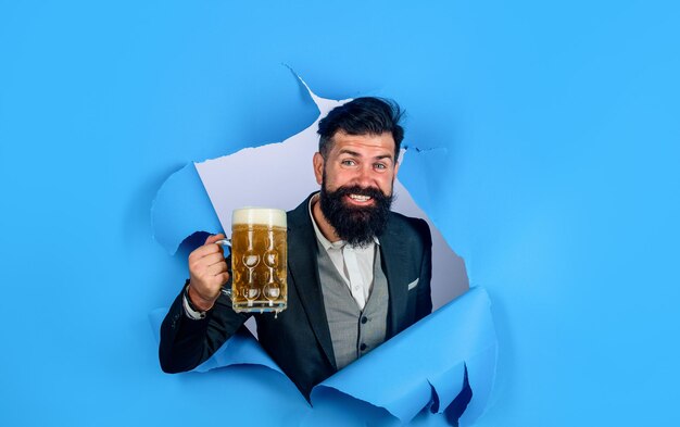 Homem barbudo bebendo cerveja homem elegante com barba segurando caneca de cerveja oktoberfest lager e cerveja escura