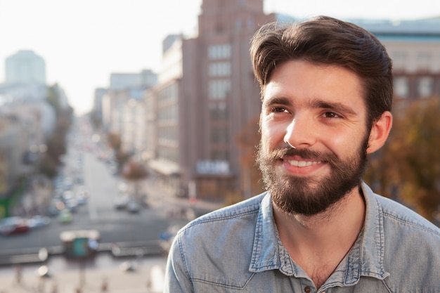 Homem barbudo bonito, aproveitando o dia quente na cidade