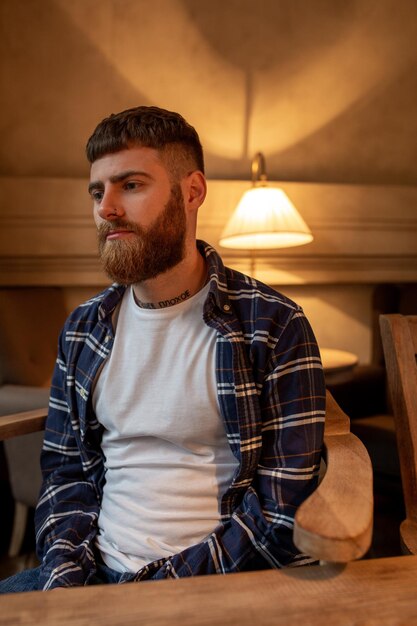 Homem barbudo bonito retrato vestindo camisa xadrez no café moderno.