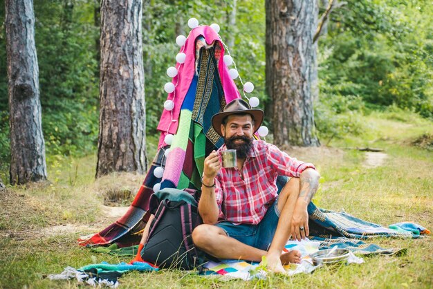 Foto homem barbudo bonito se divertindo na aventura do parque de verão, acampando no acampamento de verão da natureza e a natureza para ...
