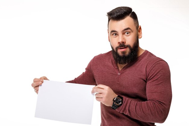 Homem barbudo bonito segurando um cartão branco. quadro em branco vazio para texto