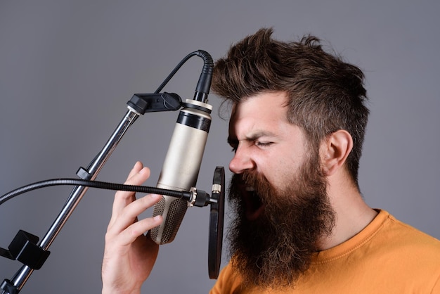Homem barbudo cantando com microfone conceito de música concerto cantor barbudo brutal com microfone