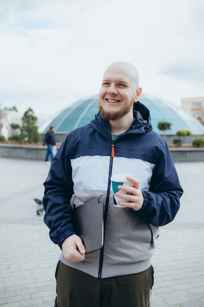 Homem barbudo careca tomando café ao ar livre