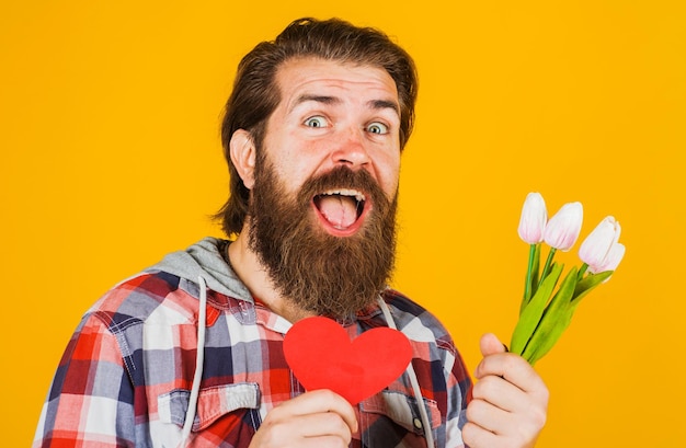 Homem barbudo com coração e flores dia dos namorados aniversário dia das mães conceito de férias de março
