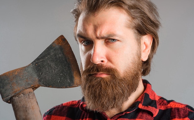 Homem barbudo com grande machado lenhador sério retrato aproximado de belo hipster com machado